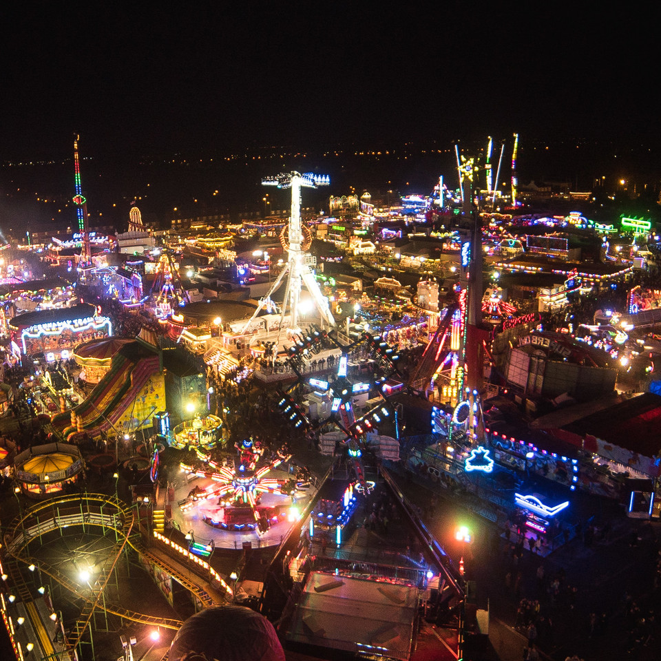 Aerial shot of the fair at night, Funfair rides with lots of lights.