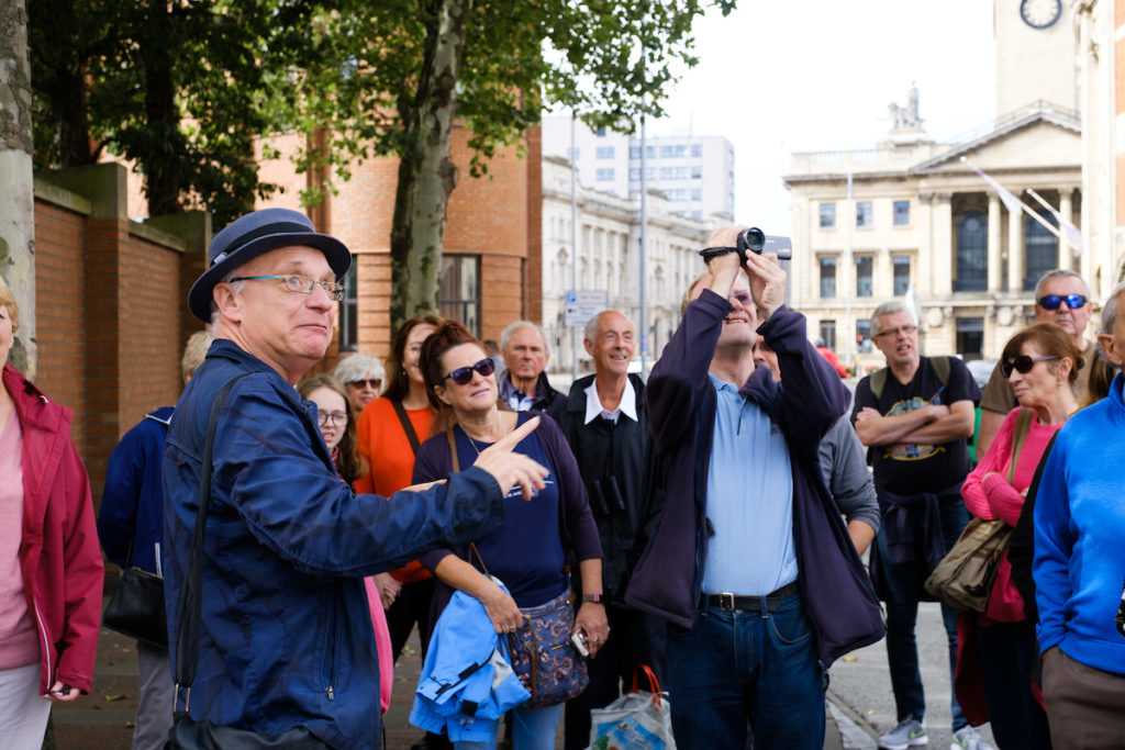 Group of people include tour guide and man with camera