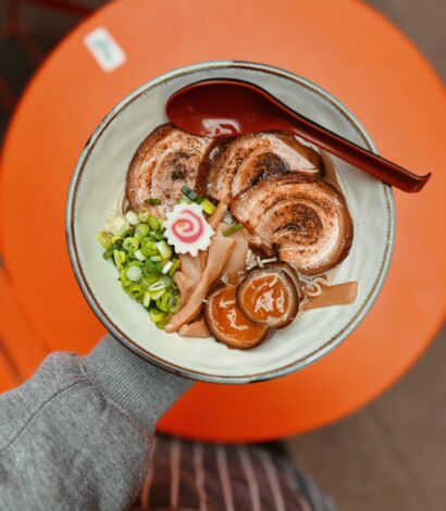 Plate of food including Chicken/Pork Paitan broth. Shoyu ('Soy') Tare. Slow cooked and charred Pork Chashu. Spring onions. Bamboo shoots. Ramen egg marinated in Soy/Mirin/Kombu. Naruto.
