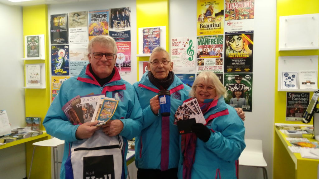 Man Holding visitor literature and visit all drawstring bag. 