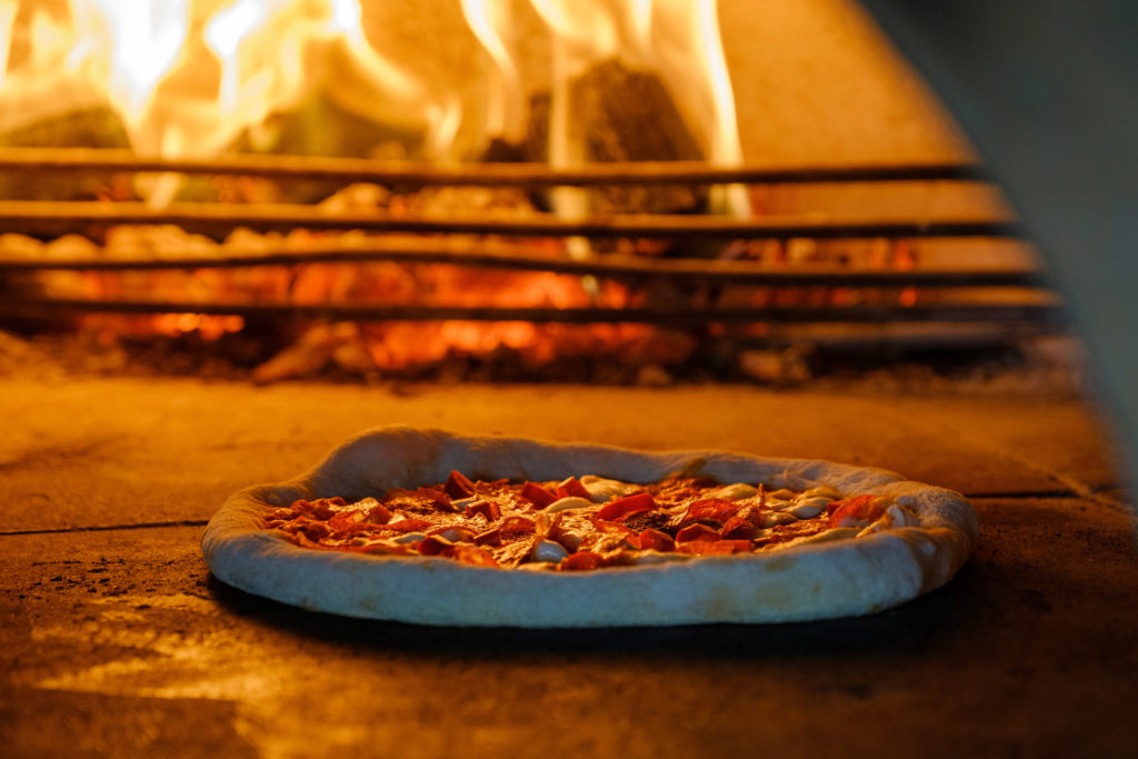 Pizza in wood burning pizza oven