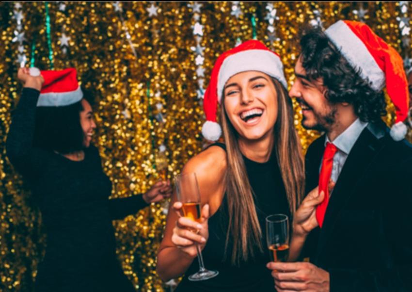 Man and Woman wearing Santa hats smiling