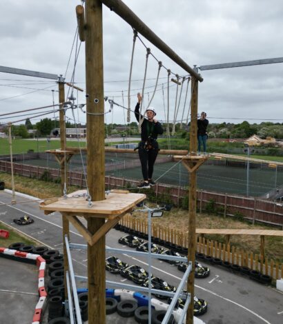Person on highropes course above go kart track
