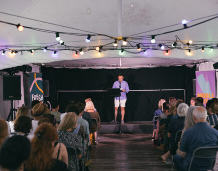 A crows sat watching a talk with a man on stage at Fresh Ink 2024